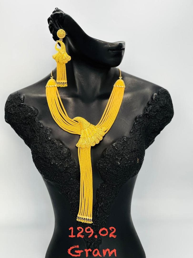 Collier en or tressé avec pendentif arc-en-ciel doré sur mannequin noir