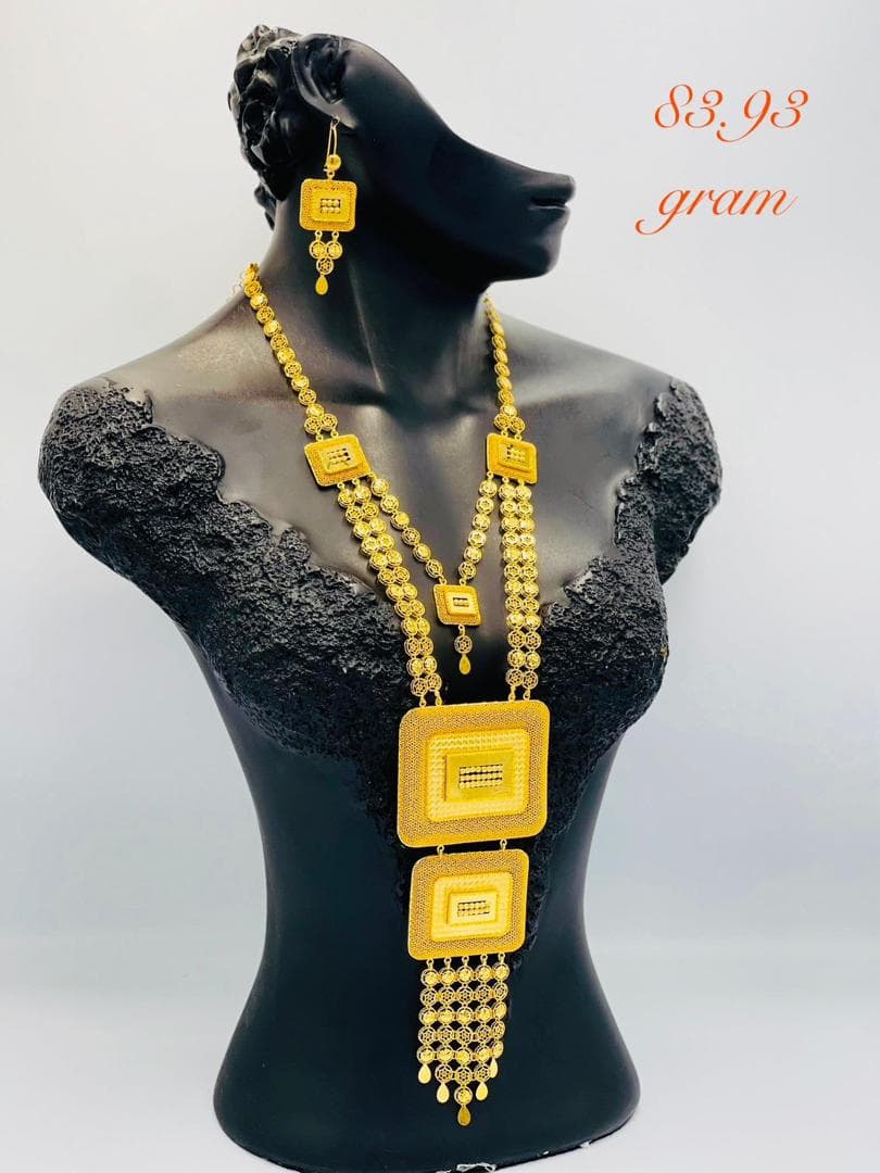 Long collier en or 21k avec pendentifs géométriques sur mannequin noir